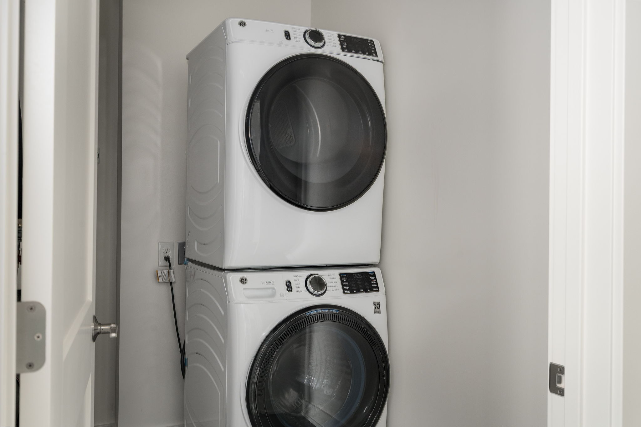 Two white washing machines stacked on top of each other.